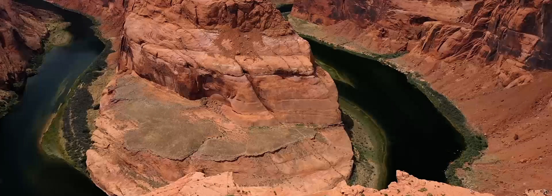 SCF video image background. Canyon landscape with water flowing through the center, surrounded by rocky cliffs.